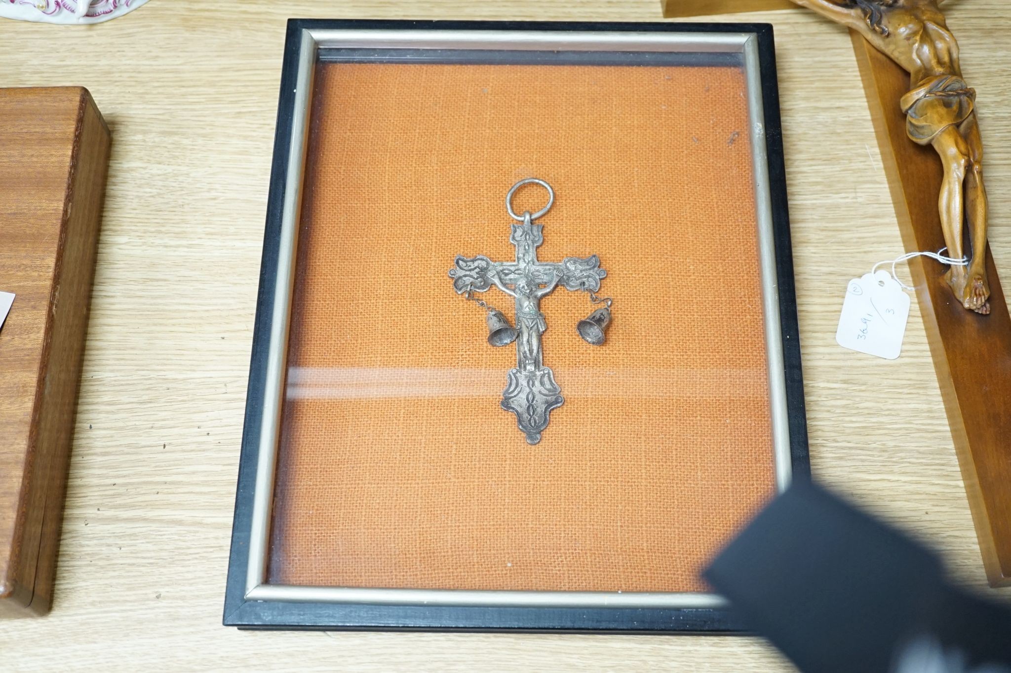 A carved crucifix and a framed metal Peruvian colonial crucifix, 50cm